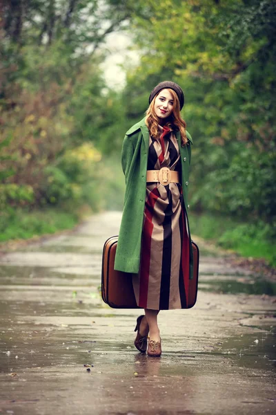 Style redhead girl with suitcase at beautiful autumn alley. — Stock Photo, Image