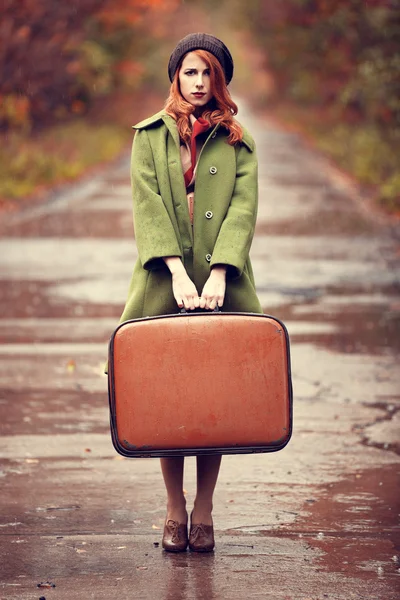 Style redhead girl with suitcase at beautiful autumn alley. — Stock Photo, Image