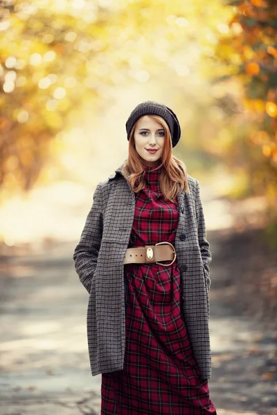 Stijl roodharige meisje op mooie herfst alley. — Stockfoto