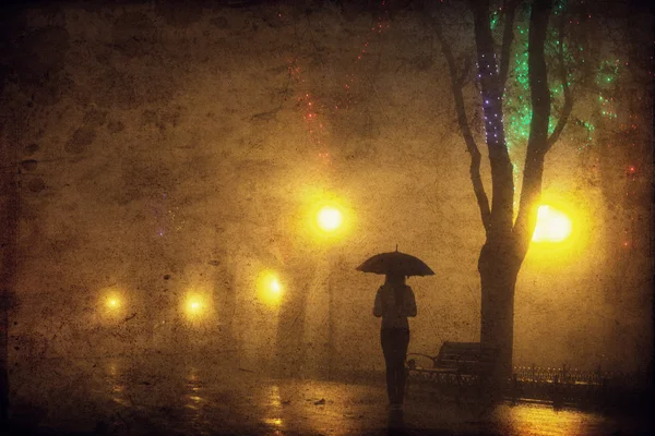 Menina solteira com guarda-chuva no beco da noite. Foto com ruído . — Fotografia de Stock