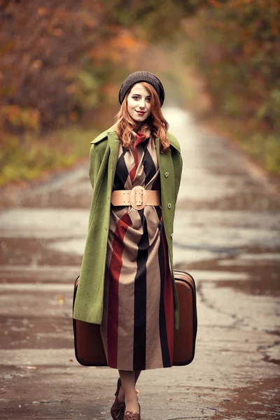 Style redhead girl with suitcase at beautiful autumn alley. — Stock Photo, Image