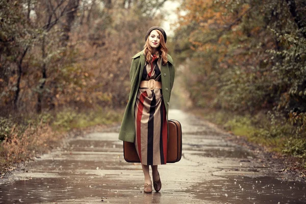 Style redhead girl with suitcase at beautiful autumn alley. — Stock Photo, Image