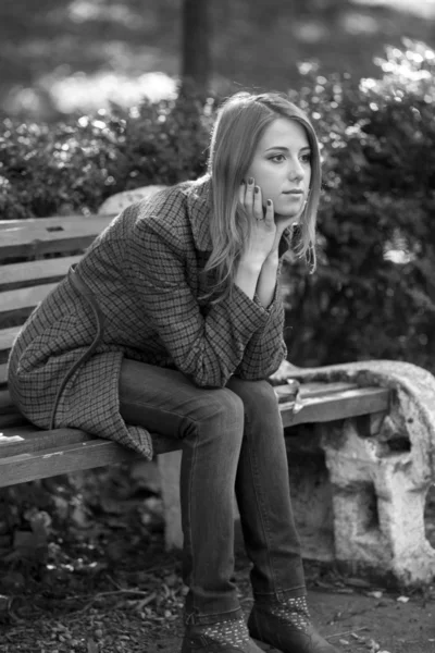 Chica pelirroja triste sentado en el banco . — Foto de Stock