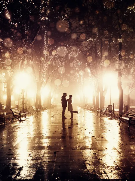 Couple walking at alley in night lights. Photo in vintage style. Stock Kép