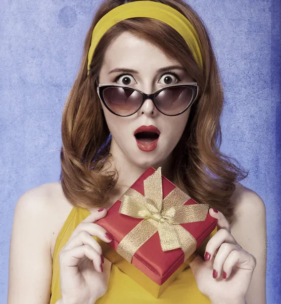 Αμερικανική κοκκινομάλλα κορίτσι σε γυαλιά ηλίου με δώρο. — Φωτογραφία Αρχείου
