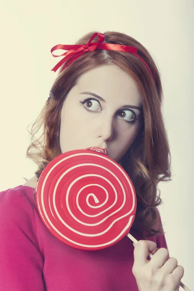 Beautiful redhead girl with lollipop. Photo in retro style. — Stock Photo, Image