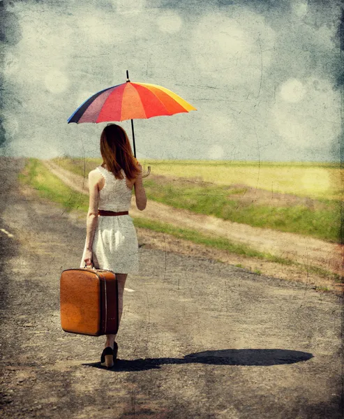 Young fashion girl with umbrella and suitcase at spring outdoor. — Stock Photo, Image