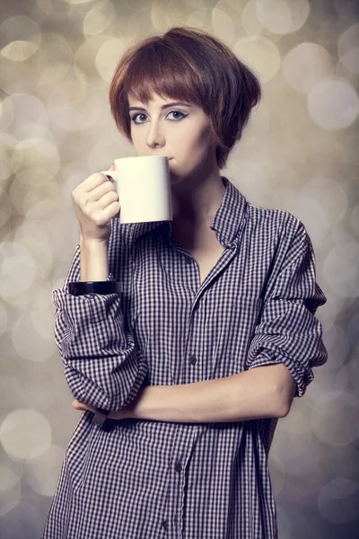 Style girl in shirt with cup at studio. — Stock Photo, Image
