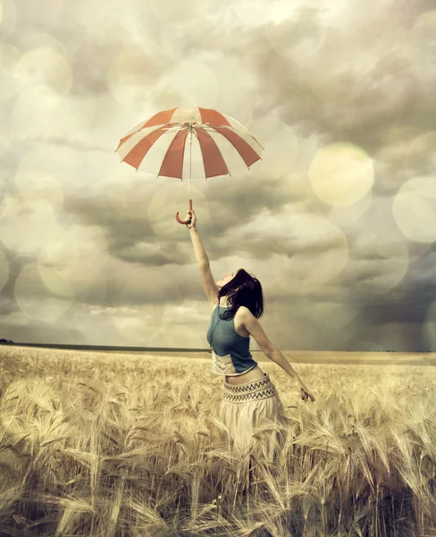 Dziewczyna w polu pszenicy z parasolem. — Zdjęcie stockowe
