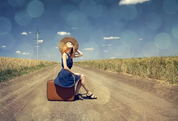 Chica solitaria con maleta en el camino del campo . — Foto de Stock