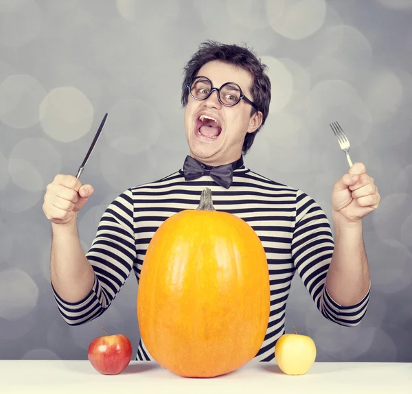 The young mad men try to eat two apples and pumpkin. — Stock Photo, Image