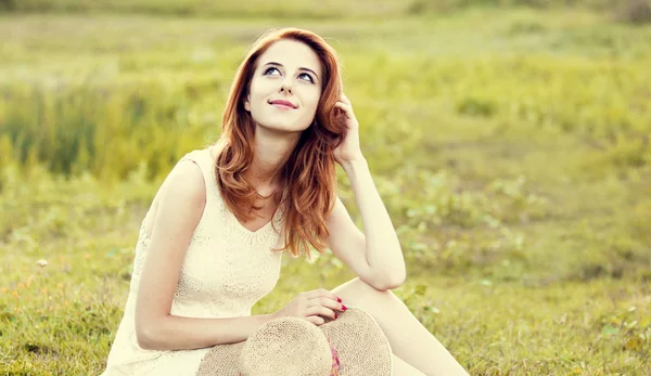 Rusovláska dívka na zelené trávě na vesnici venkovní. — Stock fotografie