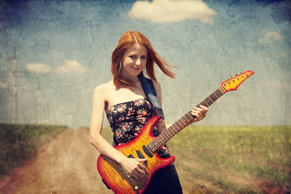 Rood-hoofd meisje met gitaar. foto in oude stijl van de afbeelding. — Stockfoto