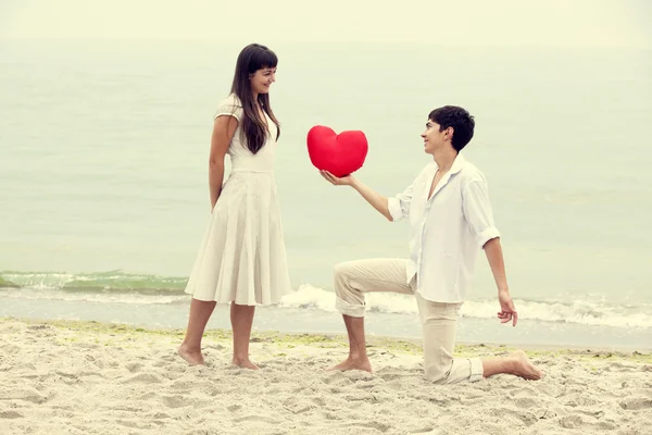 Vértes portréja boldog pár a strandon, a szív. — Stock Fotó