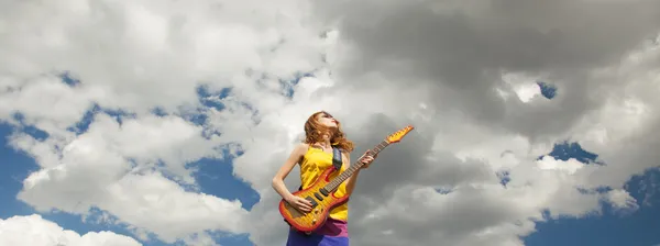 Roodharige meisje springen met gitaar op buiten. — Stockfoto