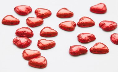 beyaz üzerine kırmızı çikolata kalp şekerler