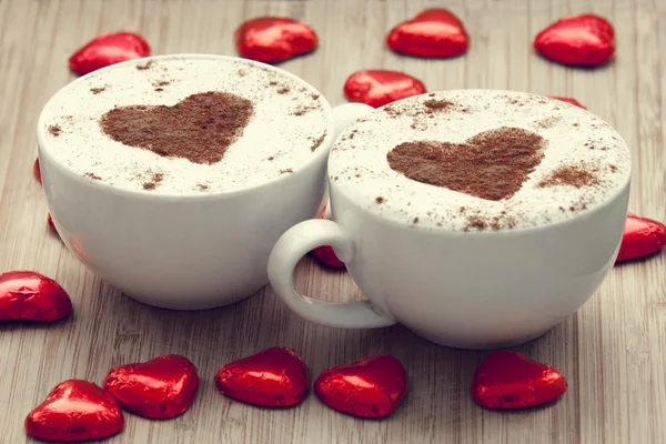 Δύο φλιτζάνι καφέ με καρδιά σύμβολο και καραμέλα γύρω από. — Φωτογραφία Αρχείου