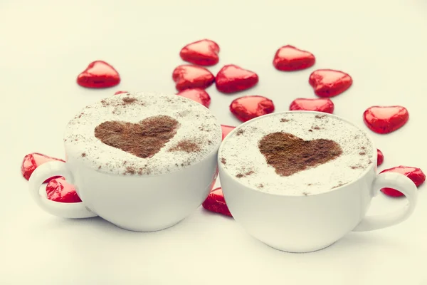 İki fincan kahve kalp simgesi ve şeker çevresinde. — Stok fotoğraf