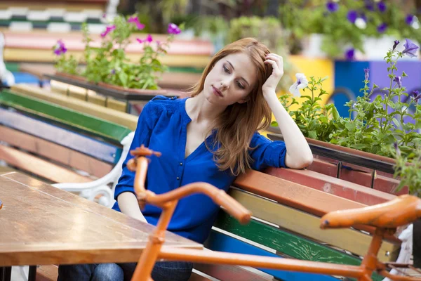 Stijl roodharige meisje zitten op de bank in het cafe — Stockfoto
