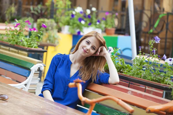 Estilo menina ruiva sentado no banco no café — Fotografia de Stock