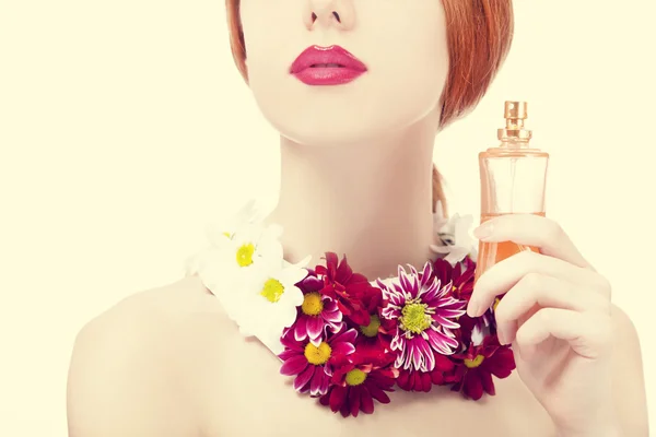 Mooi roodharig meisje met bloemen en parfum — Stockfoto