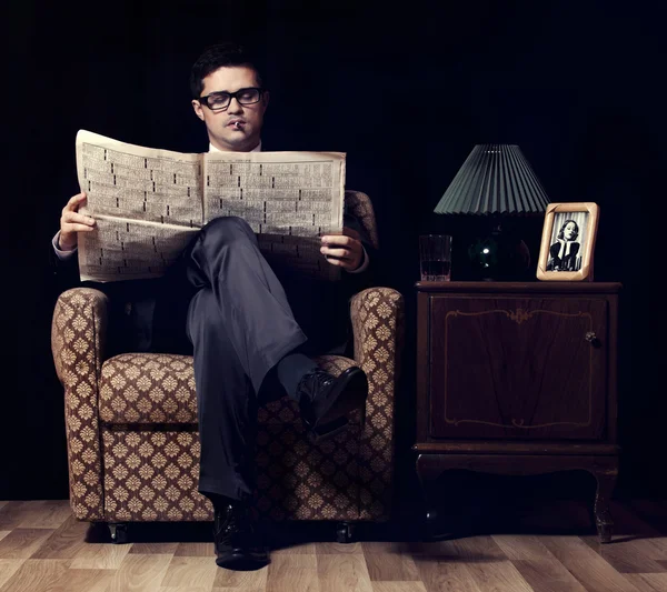 Uomo con giornale seduto in poltrona vintage — Foto Stock