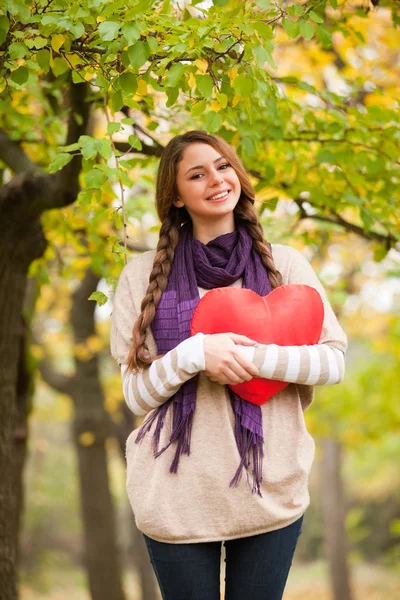 Ragazza con cuore giocattolo al parco autunnale . — Foto Stock