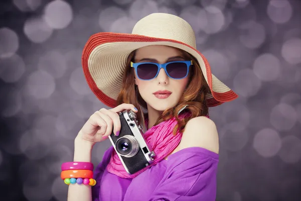 Menina ruiva engraçada em chapéu com câmera e bokeh no fundo — Fotografia de Stock