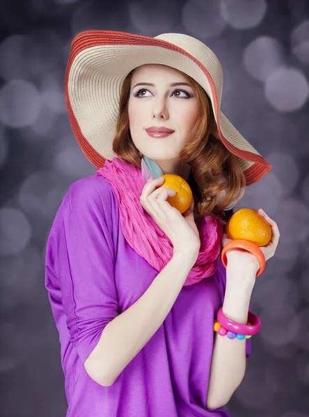 Hermosa chica pelirroja con naranjas en el fondo bokeh —  Fotos de Stock