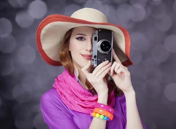 Menina ruiva engraçada em chapéu com câmera e bokeh no fundo — Fotografia de Stock