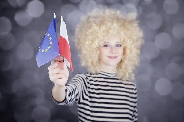 Vacker flicka med korkskruvar visar Europeiska unionen och Polen flagga — Stockfoto
