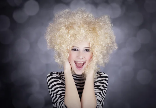 Portret van grappig meisje in blonde pruik. studio opname. — Stockfoto