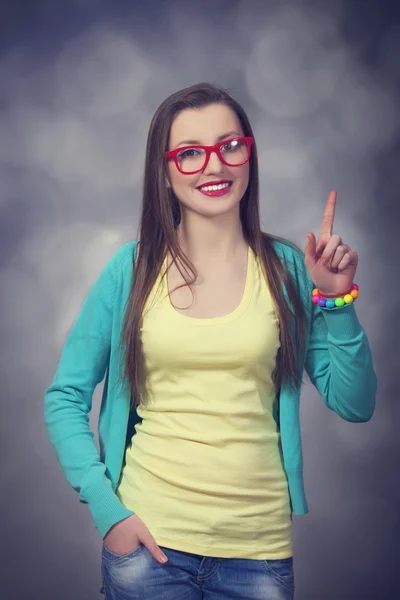 Brunettte in glasses pointing on something. — Stock Photo, Image