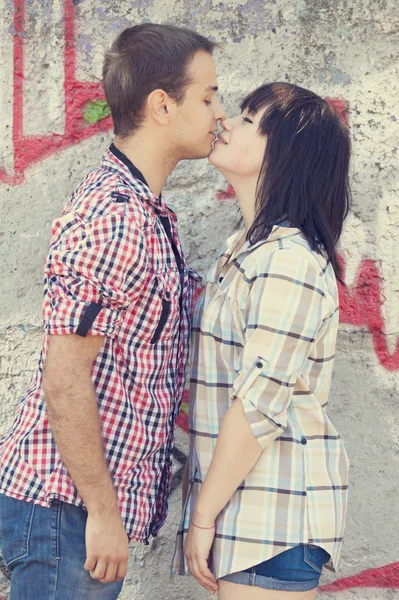 Casal jovem beijando perto de fundo graffiti . — Fotografia de Stock