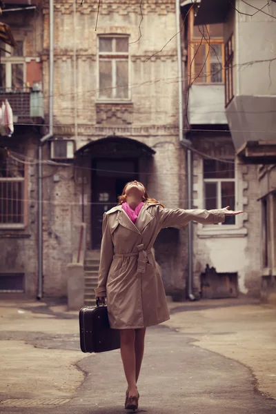 用手提箱在敖德萨院子的红发女孩. — 图库照片