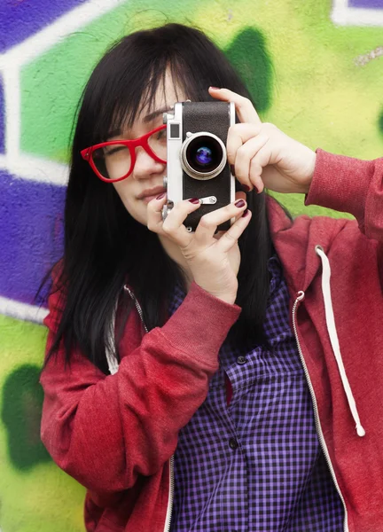 Style teen girl avec caméra debout près du mur de graffiti — Photo