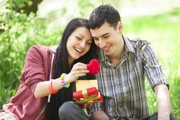 Couple with gift at green grass — Stock Photo, Image