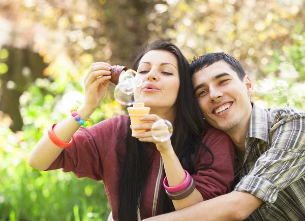 Par avkopplande i parken med bubble blower — Stockfoto