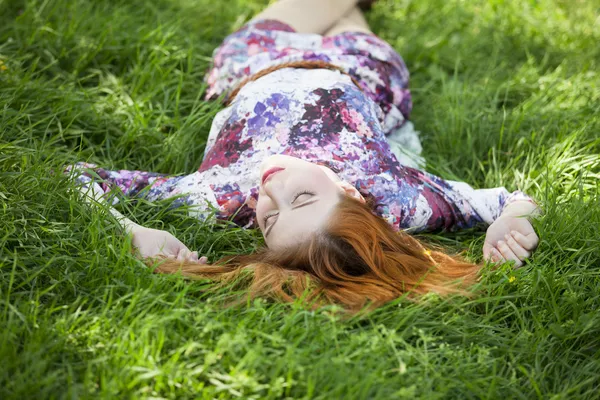 Menina bonita deitada na grama . — Fotografia de Stock