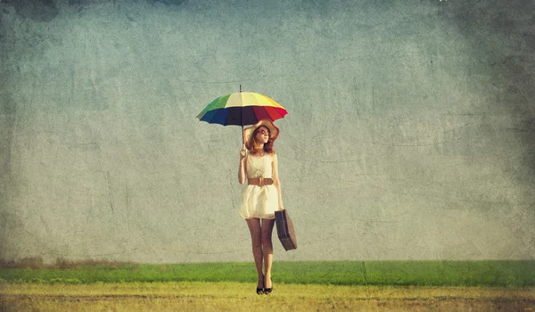 Encantadora ruiva com guarda-chuva e mala no país da primavera — Fotografia de Stock