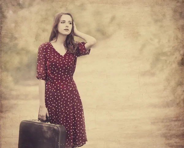 Redhead girl with suitcase at tree's alley. — Stock Photo, Image