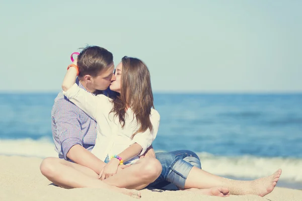 Retrato de homem jovem e mulher beijando em uma praia — Fotografia de Stock