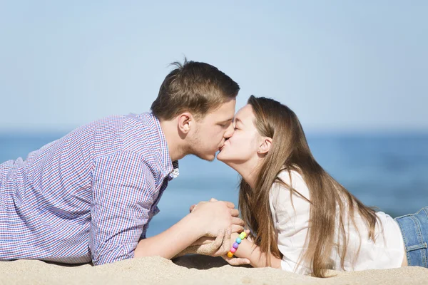 Porträt eines jungen Mannes und einer Frau, die sich am Strand küssen — Stockfoto