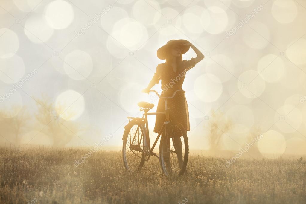 Girl on a bike in the countryside in sunrise time