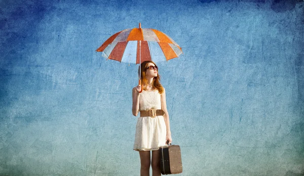 Menina ruiva com guarda-chuva no fundo do céu azul — Fotografia de Stock