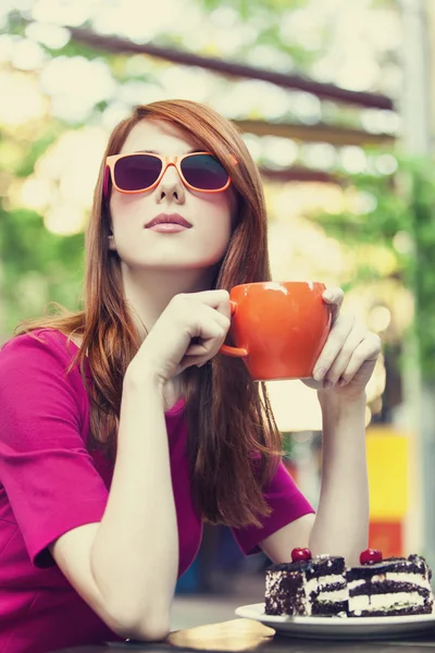 Rödhårig tjej med tårta och cup — Stockfoto