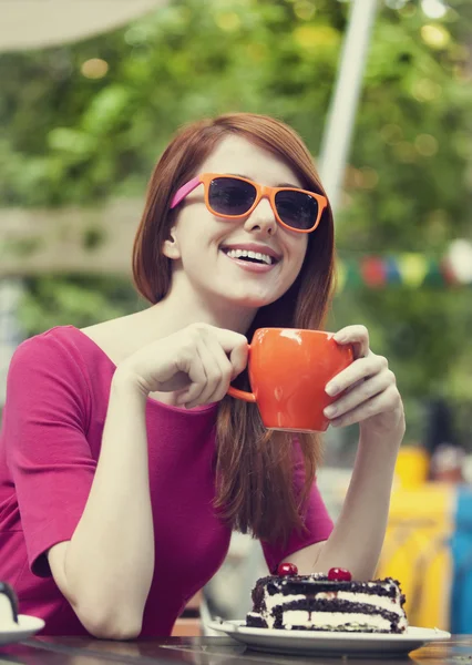 Rödhårig tjej med tårta och cup — Stockfoto