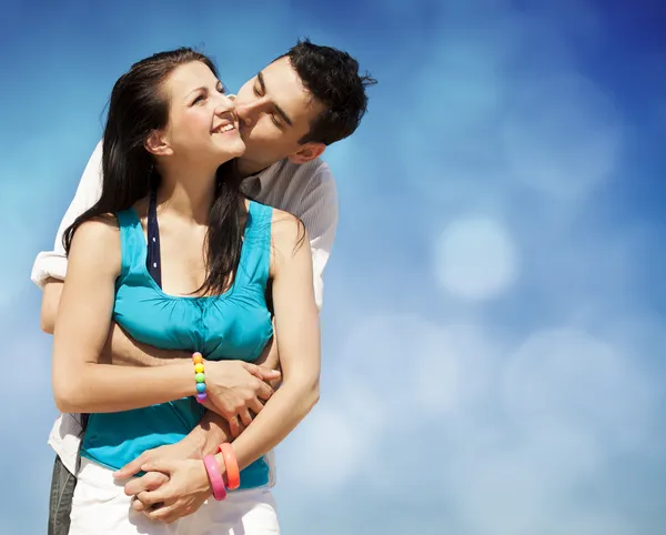Vackra par kyssas på blå himmel bakgrund — Stockfoto