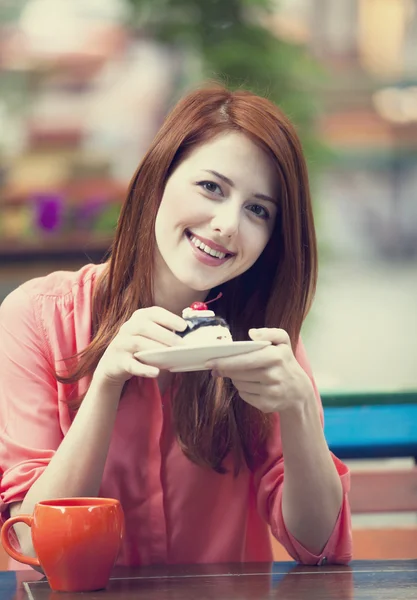 Rödhårig tjej med tårta och cup — Stockfoto