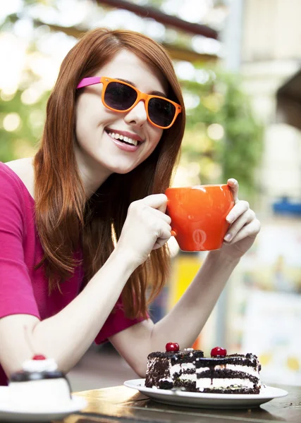 Estilo chica pelirroja con taza y pastel — Foto de Stock